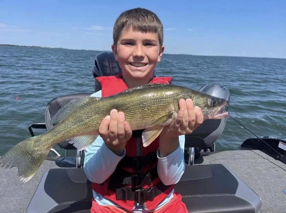 Young angler proudly holding a walleye